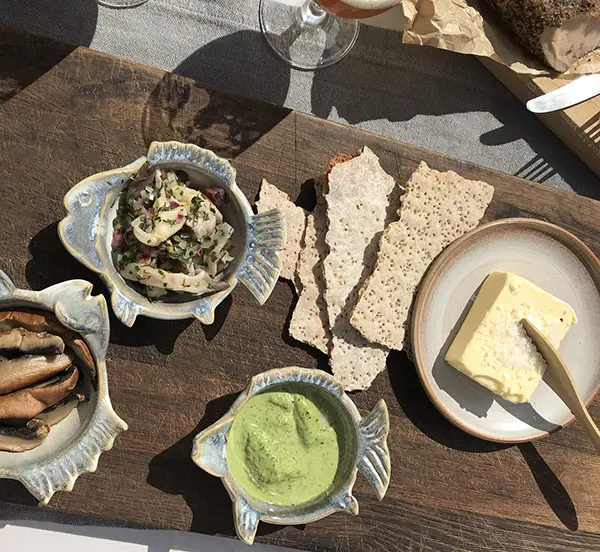 herring and crispbread on wooden tray